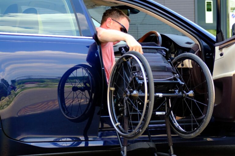 Fahrer mit einer Behinderung nimmt einen Rollstuhl aus seinem Auto