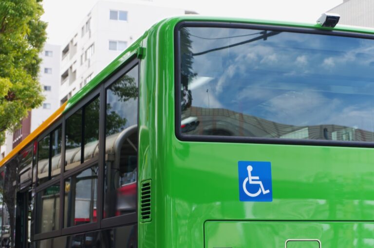 Nahaufnahme der Rückansicht eines grünen Busses mit dem internationalen Symbol für Rollstuhlzugänglichkeit.